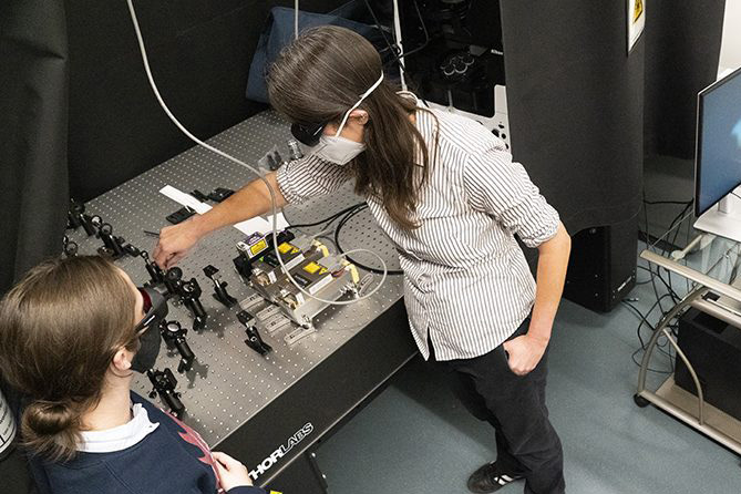 Chemistry professor Elizabeth Thrall (center), one recipient of the new James C. McGroddy Award for Innovation in Education, works with students to assemble a single-molecule fluorescence microscope in 2022. Photo by Tom Stoelker